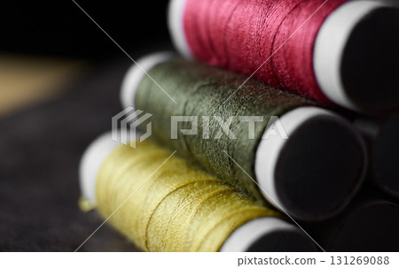 Brightly colored thread spools arranged in a stack Brightly colored thread spools arranged in a stack 131269088