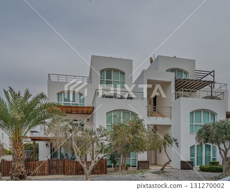 Modern architecture showcases elegance and comfort in coastal retreat with lush landscaping 131270002