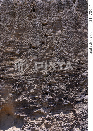 Textured rock surface revealing history with intricate patterns under bright sunlight Textured rock surface revealing history with intricate patterns under bright sunlight 131270064