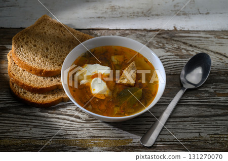 Warm soup with tender meat and fresh herbs served with rustic bread for a cozy 131270070