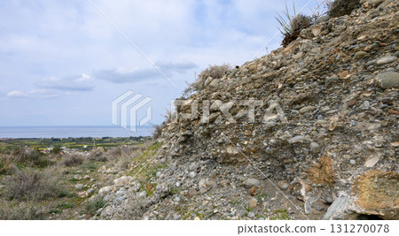 Unique geological formation reveals stones and soil against a beautiful coastal 131270078