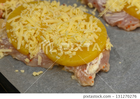Baked chicken topped with pineapple and melted cheese ready for the oven 131270276