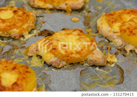 Homemade cheesy pineapple chicken bites baked to perfection on a silver tray 131270415