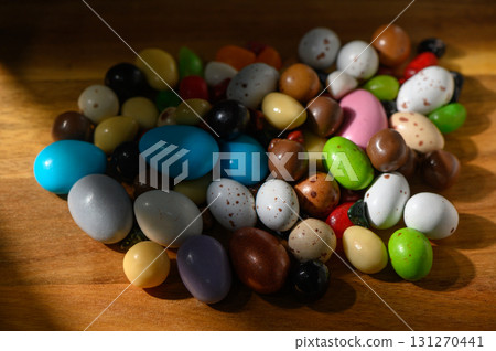Colorful assortment of decorative eggs scattered on a wooden table in springtime 131270441