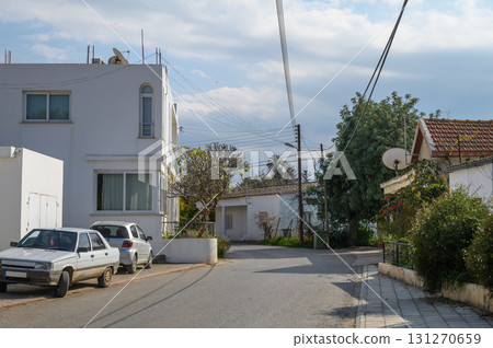 Cozy street in a peaceful neighborhood with charming houses and clear skies Cozy street in a peaceful neighborhood with charming houses and clear skies 131270659