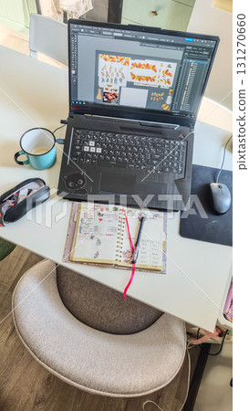 Top view of a home workspace on a kitchen table with laptop, planner, mug and mouse Top view of a home workspace on a kitchen table with laptop, planner, mug and mouse 131270660