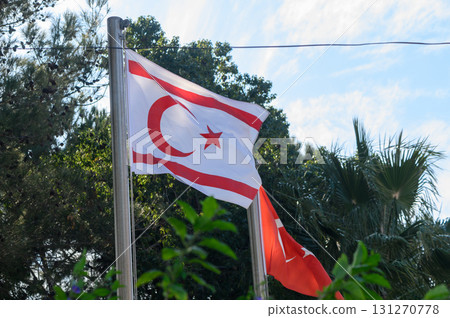 Flags waving proudly under a blue sky in a sunlit outdoor setting 131270778
