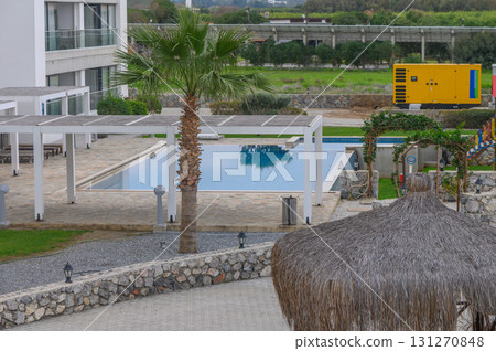 Relaxing by the tranquil poolside oasis surrounded by lush greenery and vibrant sunshine Relaxing by the tranquil poolside oasis surrounded by lush greenery and vibrant sunshine 131270848