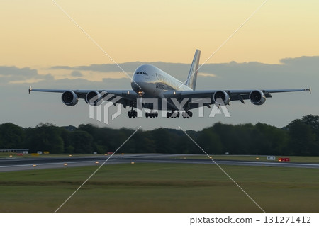 Airplane takes off from the runway against a vibrant sunset sky with clouds 131271412
