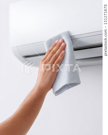 Technician hand carefully wiping and cleaning home air conditioner. Professional maintenance service for clean appliance, ensuring healthy and comfortable indoor environment 131271678