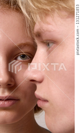 Intimate gaze of blond man and red-haired woman facing each other in close studio portrait 131271853