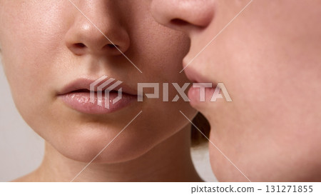 Close focus on lips of red-haired woman with blond man leaning near in tender studio portrait 131271855
