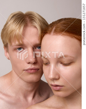 Tender portrait of blond man leaning close to red-haired woman with downcast eyes Tender portrait of blond man leaning close to red-haired woman with downcast eyes 131271857