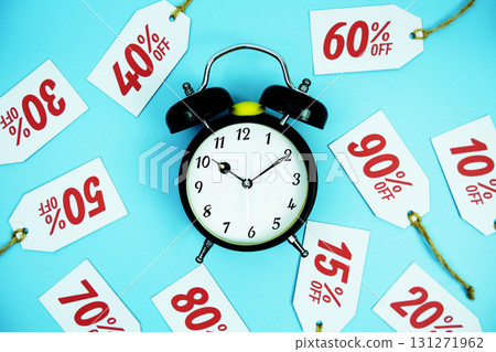 Clock surrounded by various discount tags with percentages like 10%, 20%, 30%, up to 90% off, set against a bright blue background Clock surrounded by various discount tags with percentages like 10%, 20%, 30%, up to 90% off, set against a bright blue background 131271962