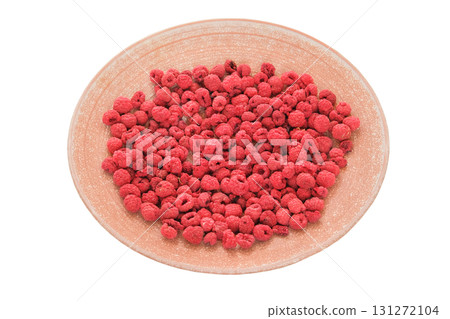 Quick snacks. Dehydrated food. Dried raspberries on a ceramic plate isolated on a white background. Quick snacks. Dehydrated food. Dried raspberries on a ceramic plate isolated on a white background. 131272104
