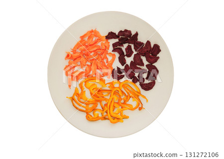 Top view. Freeze-dried vegetable for travel. Dried beetroot, sweet pepper and carrot on a ceramic plate isolated on a white background. Various dry of vegetables. 131272106
