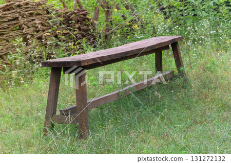 Retro wooden bench. Old wooden bench in nature background. Village furniture. Sunny day. Retro wooden bench. Old wooden bench in nature background. Village furniture. Sunny day. 131272132