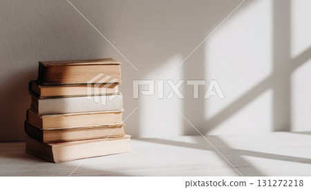 A stack of antique books illuminated by the light of a window_1 A stack of antique books illuminated by the light of a window_1 131272218