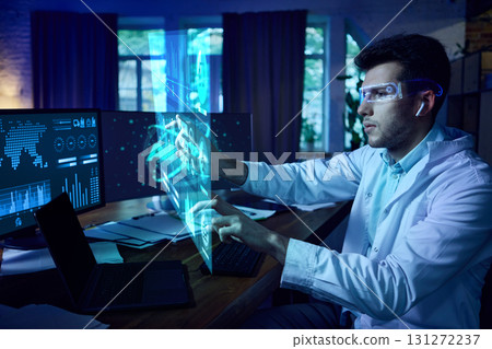 Scientist wearing AR glasses interacting with futuristic AI interface and digital dashboards. Collage 131272237