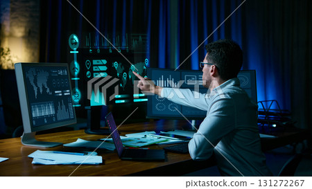 Analyst pointing at digital logistics data screens in modern workspace. Collage 131272267