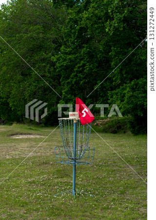 Outdoor disc golf basket with red flag in green park Outdoor disc golf basket with red flag in green park 131272449