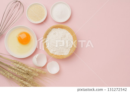 Cooking and baking image (flour, eggs, salt, brown sugar, wheat ears) pink background 131272542