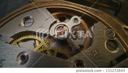 Macro Close Up Shot of Watch Mechanism with Moving Gears and Balance Wheel Macro Close Up Shot of Watch Mechanism with Moving Gears and Balance Wheel 131272643