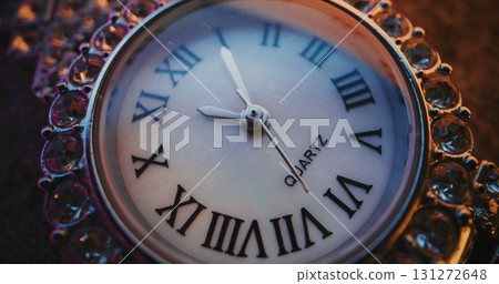 Close Up of Decorative Clock with Roman Numerals with Ornate Jeweled Frame Showing Precise Time 131272648