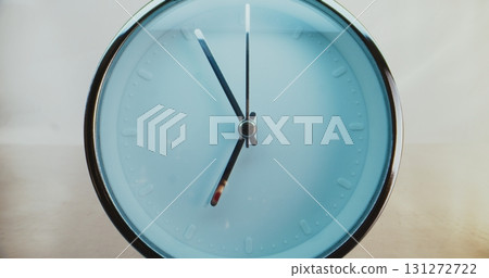 Close Up of Minimalist Round Wall Clock on Warm Background with Moving Clock Hands 131272722