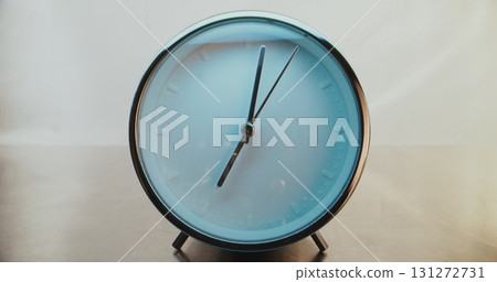 Close Up of Round Wall Clock with Minimalist Design on Warm Background with Moving Clock Hands Close Up of Round Wall Clock with Minimalist Design on Warm Background with Moving Clock Hands 131272731