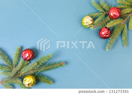 Christmas dark blue background with green Christmas tree branches and red, yellow, and orange decorative balls, with space for text in the center for greetings, suggestions, labels, and your design. Christmas dark blue background with green Christmas tree branches and red, yellow, and orange decorative balls, with space for text in the center for greetings, suggestions, labels, and your design. 131273391