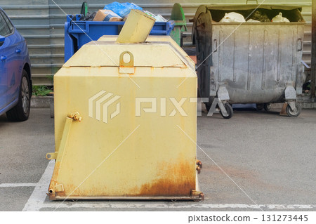 Metal yellow trash can. Dumpsters being full with garbage. Garbage, waste lots, junk dump. Metal yellow trash can. Dumpsters being full with garbage. Garbage, waste lots, junk dump. 131273445