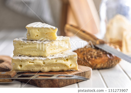 Camembert cheese on wooden cutting board. French cheese with mold on the surface. Camembert cheese on wooden cutting board. French cheese with mold on the surface. 131273907