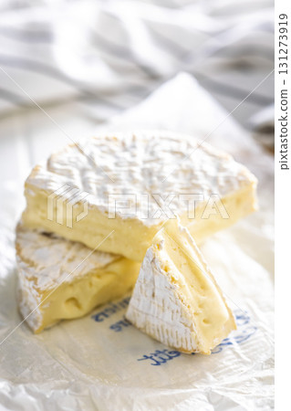 Camembert cheese on wrapping paper. French cheese with mold on the surface. Camembert cheese on wrapping paper. French cheese with mold on the surface. 131273919