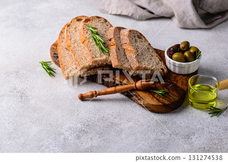 Fresh bread, olive oil and mix of olives. 131274538