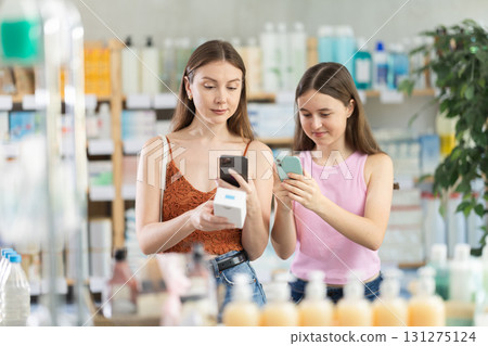 Woman with daughter scanning qr code of pills 131275124