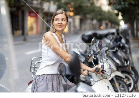 Woman rents moped, starts journey at parking lot Woman rents moped, starts journey at parking lot 131275130