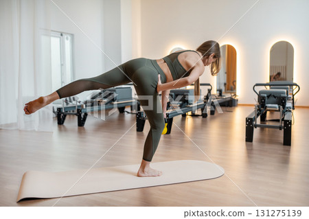 Foot work and core exercise with dumbbell illuminated by sunlight. Fit, healthy and strong authentical body. Fitness concept 131275139