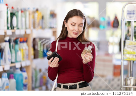 Young woman chooses perfume in store Young woman chooses perfume in store 131275154