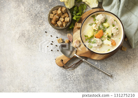 Hearty meatball soup with vegetables and herbs for a cozy meal. Hearty meatball soup with vegetables and herbs for a cozy meal. 131275210