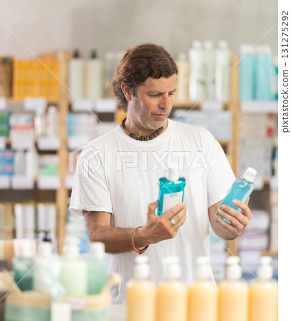 Adult man chooses mouthwash at pharmacy 131275292