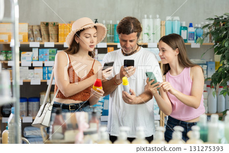 Family with teen girl in pharmacy scans QR code mosquito repellent product Family with teen girl in pharmacy scans QR code mosquito repellent product 131275393