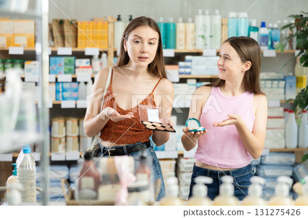 Woman with daughter choosing cosmetics in pharmacy 131275426