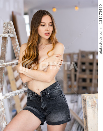 Portrait of a desirable sexy woman posing on a construction site Portrait of a desirable sexy woman posing on a construction site 131275450