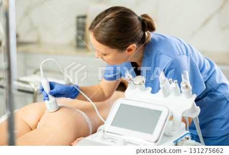 Adult woman cosmetologist performs rejuvenating procedure on butt of young woman Adult woman cosmetologist performs rejuvenating procedure on butt of young woman 131275662