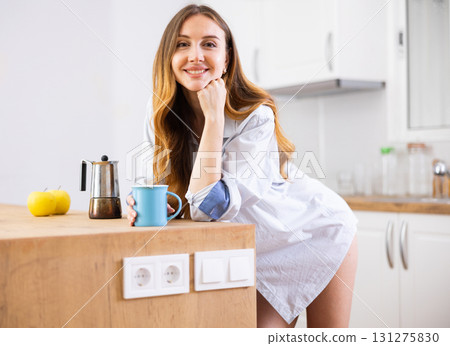 Woman drinking coffee at kitchen in morning 131275830