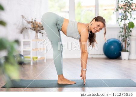 Experienced girl fitness club teacher performs ardha uttanasana Experienced girl fitness club teacher performs ardha uttanasana 131275836