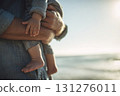 特寫鏡頭:一位父親在海灘上抱著一個嬰兒 特寫鏡頭:一位父親在海灘上抱著一個嬰兒 131276011