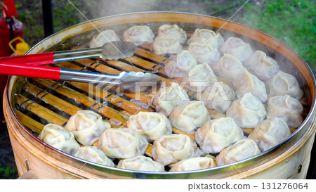 Cooking manti. A traditional Central Asian dish. Street food. 131276064