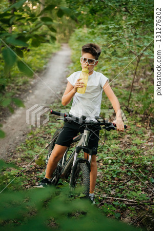 A Youth Enjoying a Refreshing Beverage While Biking Through Natures Scenic Beauty 131276202